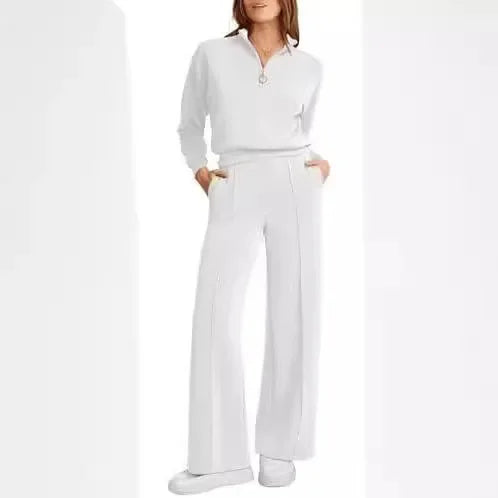 Mulher usando conjunto Royal Comfort coral: blusa meio-zip e calça wide leg de moletom premium, visual elegante e confortável com mãos nos bolsos.

